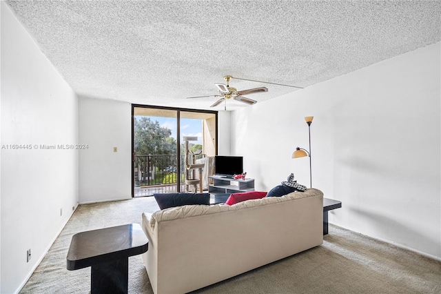 living room with ceiling fan, a wall of windows, a textured ceiling, and light carpet