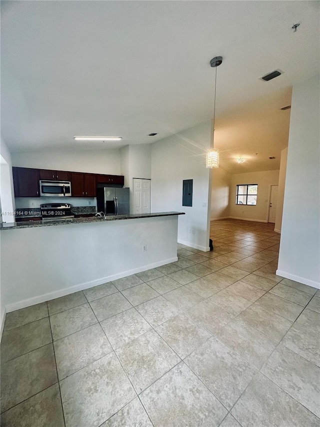 kitchen featuring dark stone counters, kitchen peninsula, appliances with stainless steel finishes, decorative light fixtures, and dark brown cabinets