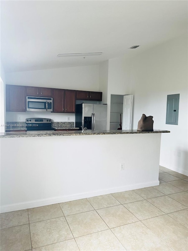 kitchen with appliances with stainless steel finishes, electric panel, vaulted ceiling, and dark stone counters