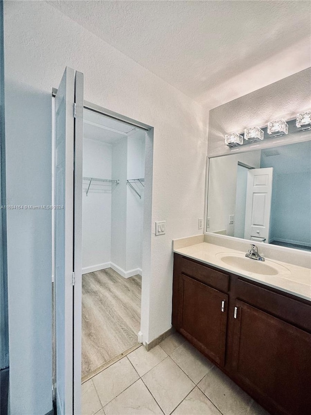 bathroom featuring vanity, wood-type flooring, and a textured ceiling