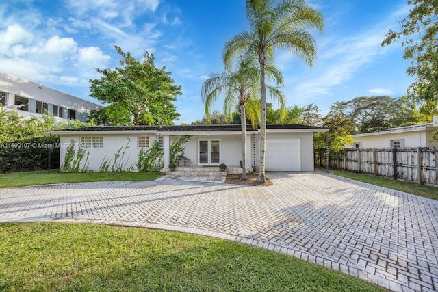 ranch-style house with a front lawn, a garage, and french doors