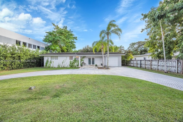 ranch-style home featuring a garage and a front lawn