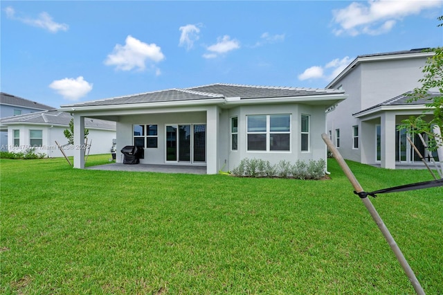 back of property with a patio and a lawn