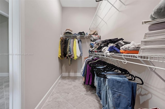 walk in closet with light tile patterned floors