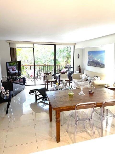 living room featuring a wealth of natural light, light tile patterned floors, and a wall of windows