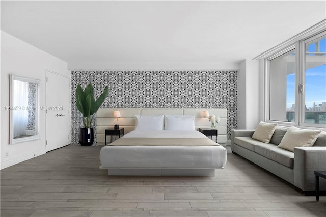 1100 W Ave Unit 918, Miami Beach, FL 33139 - bedroom with an accent wall, wallpapered walls, and wood finished floors