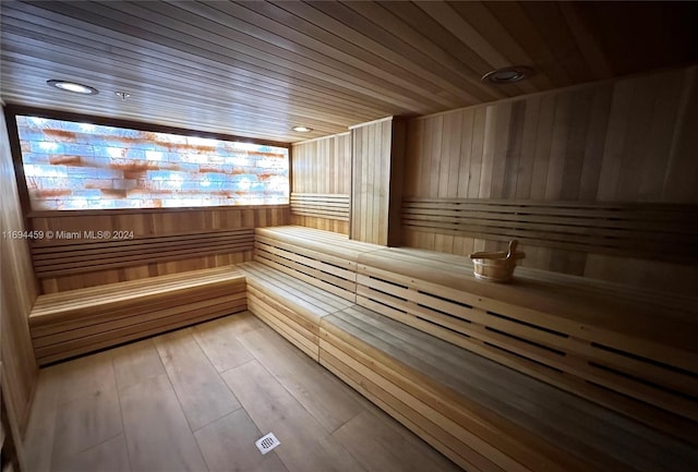 view of sauna featuring hardwood / wood-style flooring, wood ceiling, and wooden walls