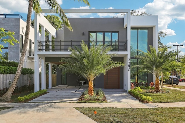 view of front of house with a garage, a carport, and a balcony