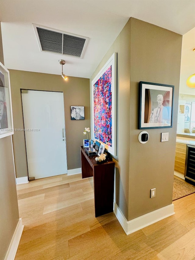 corridor featuring wood-type flooring and beverage cooler