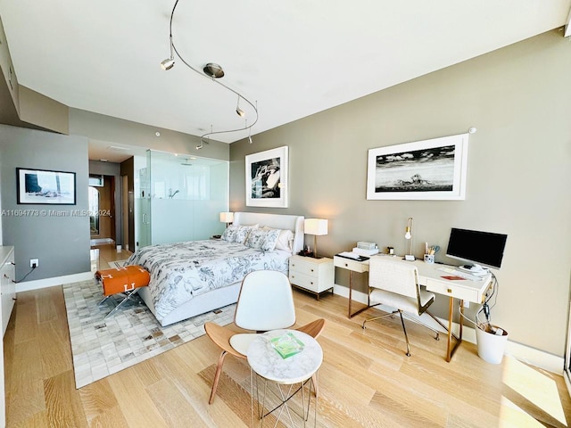 bedroom with track lighting and light hardwood / wood-style flooring