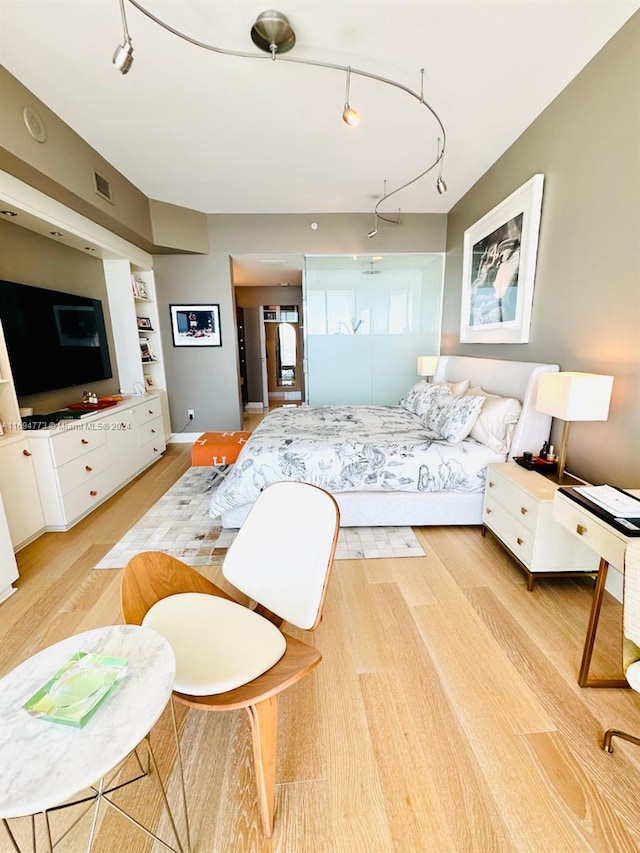 bedroom featuring light hardwood / wood-style flooring and track lighting