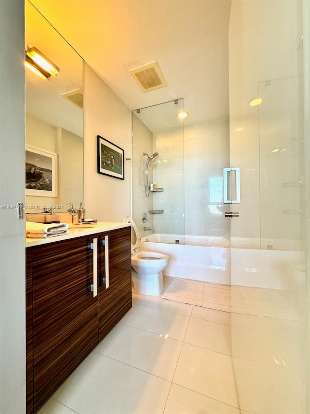 full bathroom featuring tile patterned floors, tiled shower / bath combo, toilet, and vanity