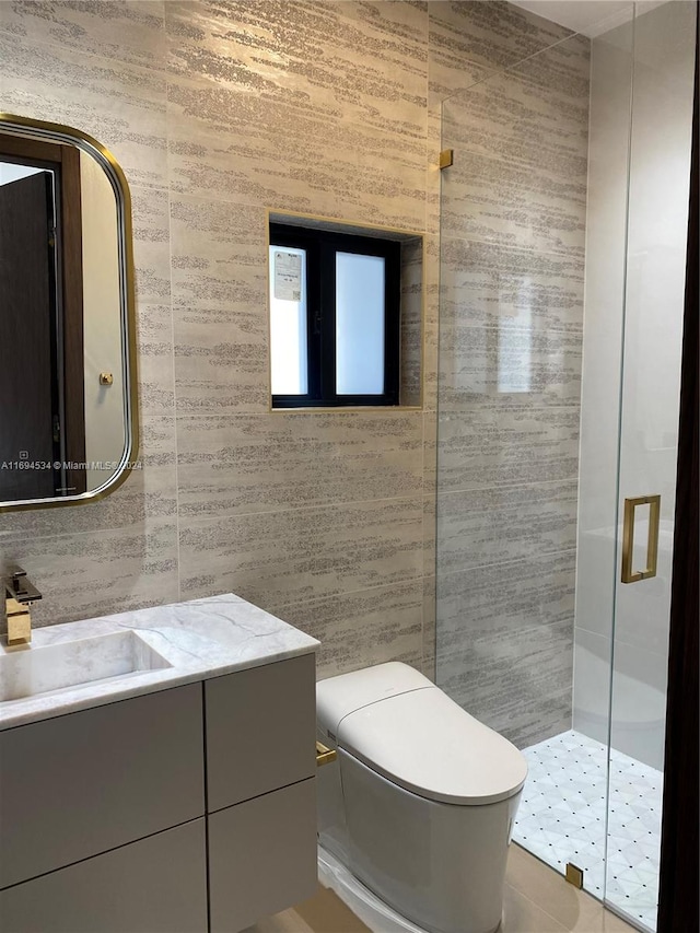 bathroom featuring vanity, toilet, tile walls, and a shower with shower door