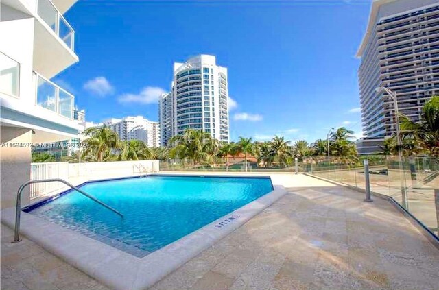 view of pool featuring a water view and a hot tub