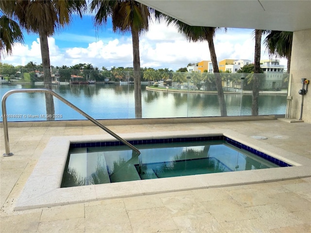 view of swimming pool featuring a water view and a hot tub