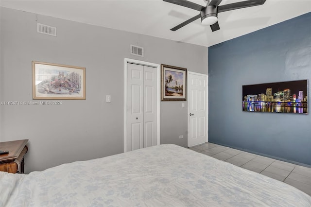 bedroom featuring ceiling fan, a closet, and light tile patterned floors