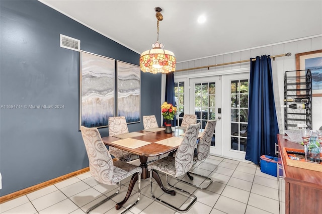 dining room with crown molding, french doors, and light tile patterned floors