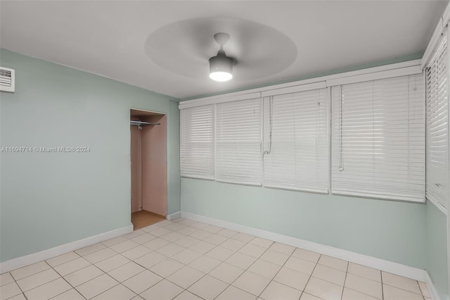 tiled spare room featuring ceiling fan