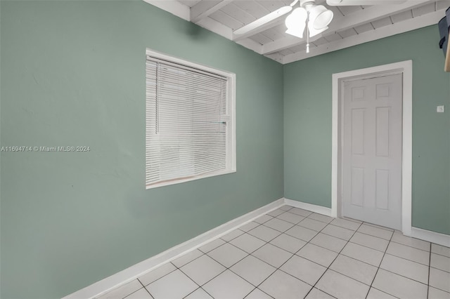 tiled empty room featuring beamed ceiling, ceiling fan, and wood ceiling