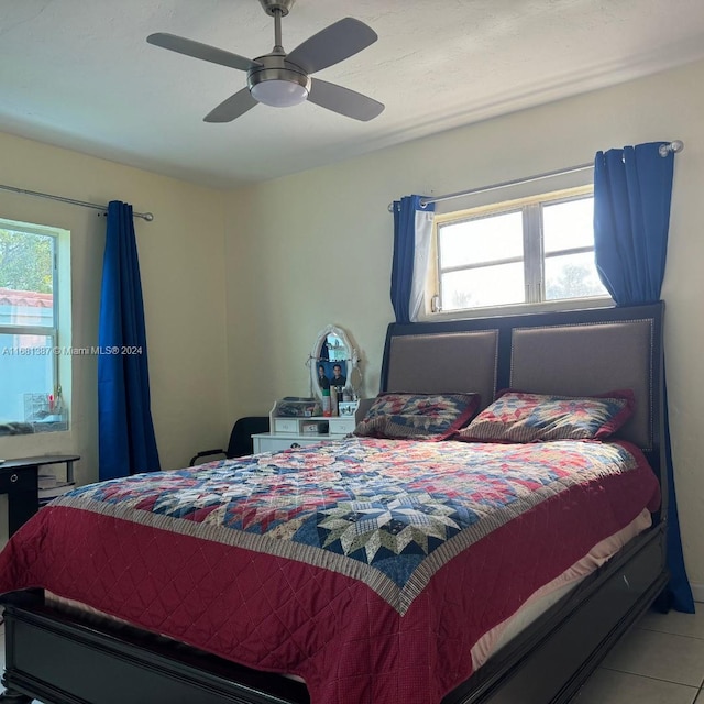 tiled bedroom with ceiling fan and multiple windows