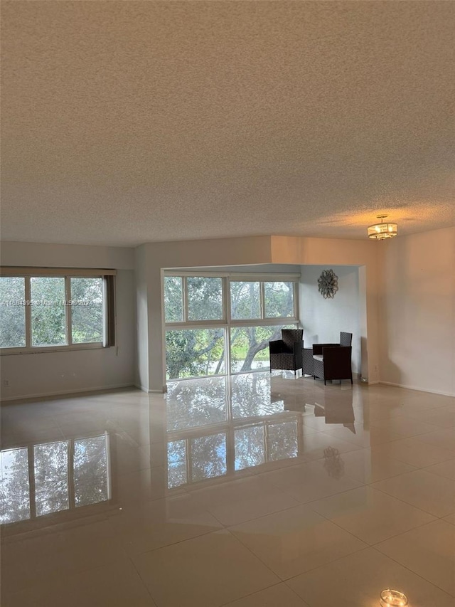 unfurnished living room featuring light tile patterned floors and a textured ceiling