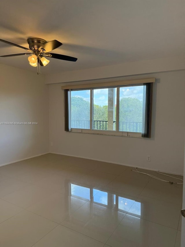 tiled empty room featuring ceiling fan