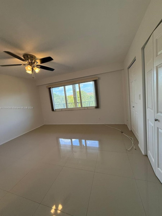 empty room featuring light tile patterned floors and ceiling fan