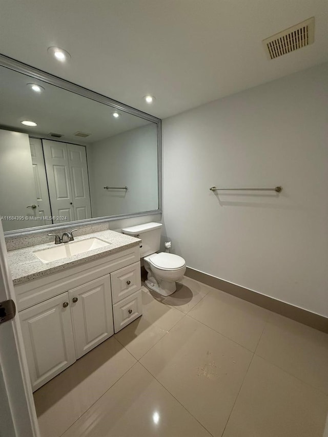 bathroom featuring tile patterned flooring, vanity, and toilet