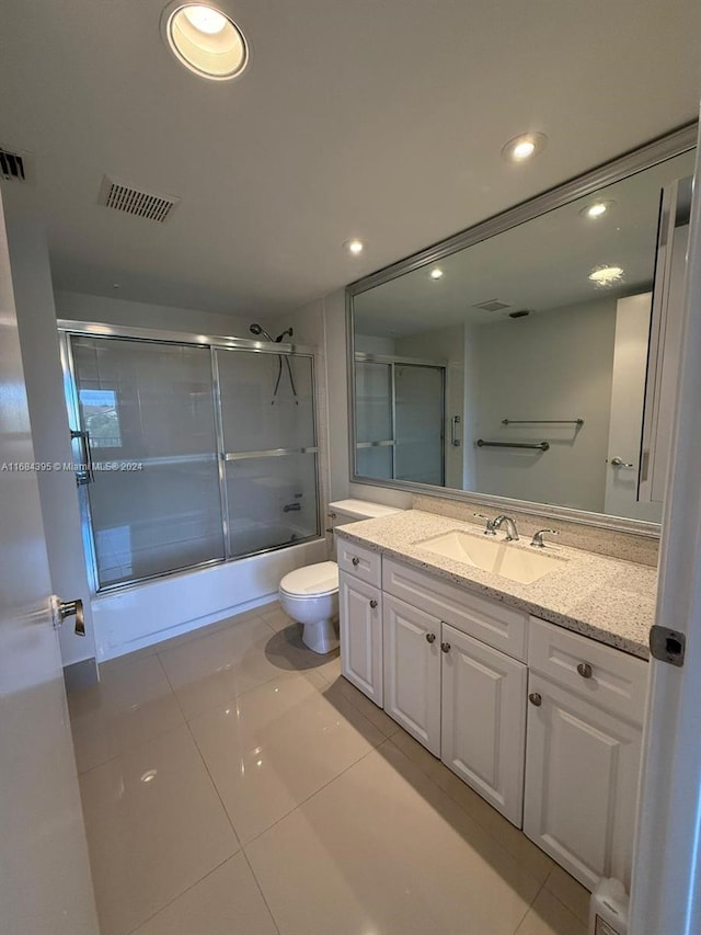 full bathroom featuring tile patterned flooring, vanity, toilet, and shower / bath combination with glass door