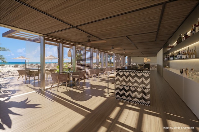 wooden deck featuring a water view and a beach view