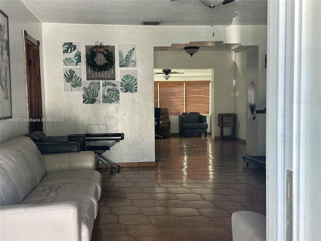 living room featuring a textured ceiling and ceiling fan