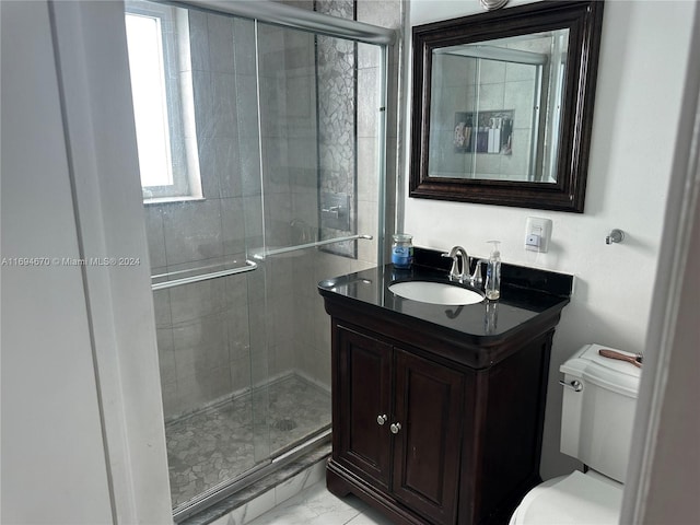 bathroom featuring vanity, toilet, and an enclosed shower