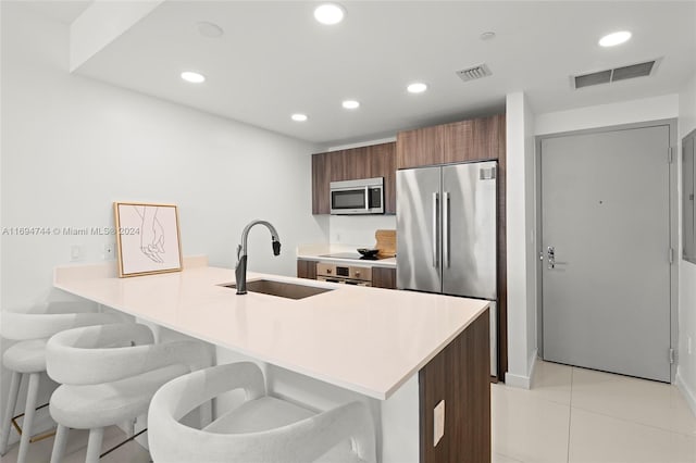 kitchen with a breakfast bar, kitchen peninsula, sink, and stainless steel appliances