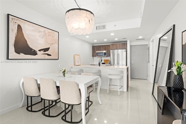 dining area featuring light tile patterned flooring and a chandelier