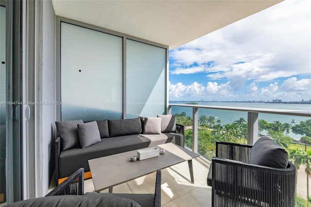 balcony featuring outdoor lounge area and a water view