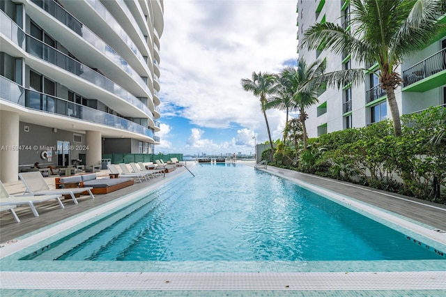 view of swimming pool with a patio and a water view