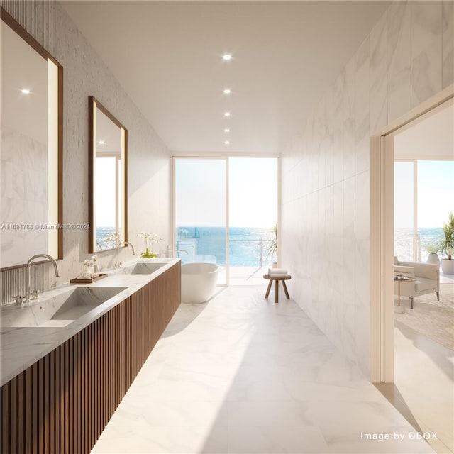 bathroom with a bathing tub, vanity, and a water view