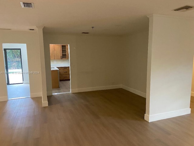 unfurnished room with hardwood / wood-style floors and ornamental molding