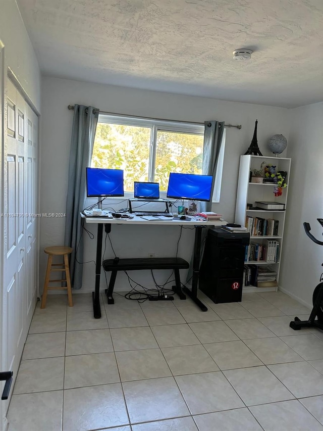 office area featuring light tile patterned flooring and a textured ceiling