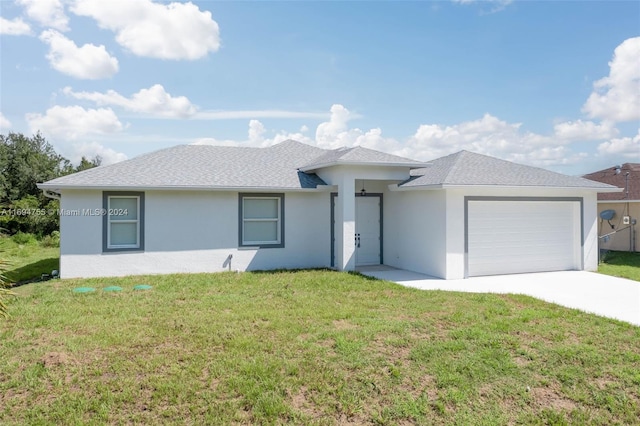 view of front of home with a front yard and a garage