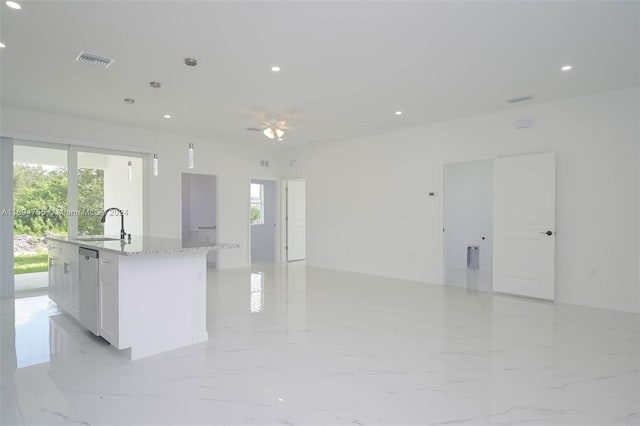 kitchen with dishwasher, a kitchen island with sink, white cabinets, hanging light fixtures, and light stone counters