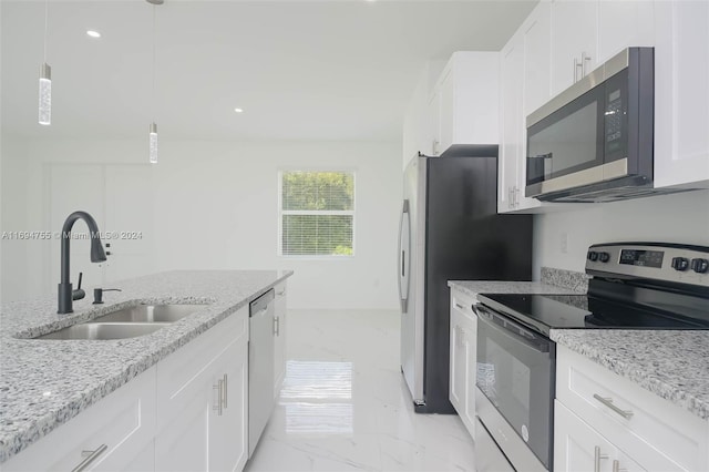 kitchen featuring light stone countertops, stainless steel appliances, sink, white cabinetry, and hanging light fixtures