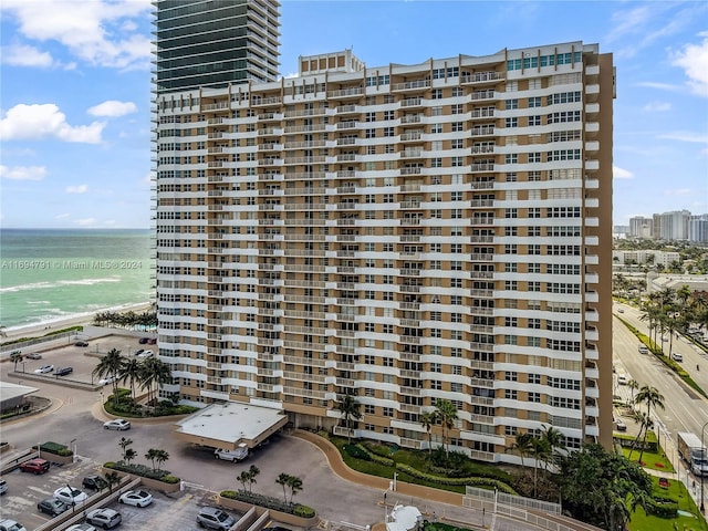 view of building exterior featuring a water view and a view of the beach