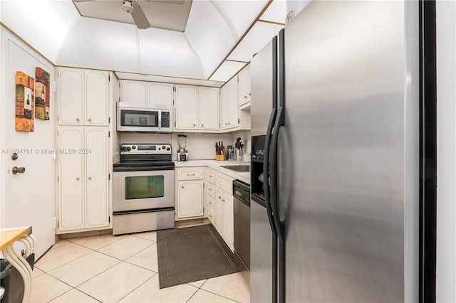 kitchen with white cabinets, appliances with stainless steel finishes, light tile patterned floors, and sink