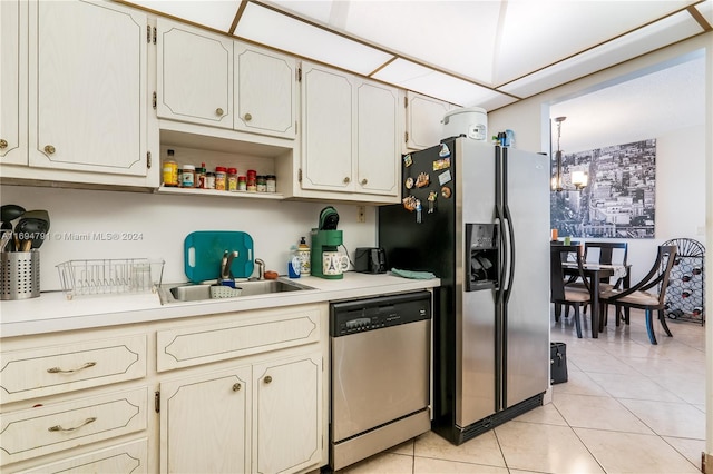 kitchen featuring sink, light tile patterned flooring, stainless steel appliances, and a notable chandelier