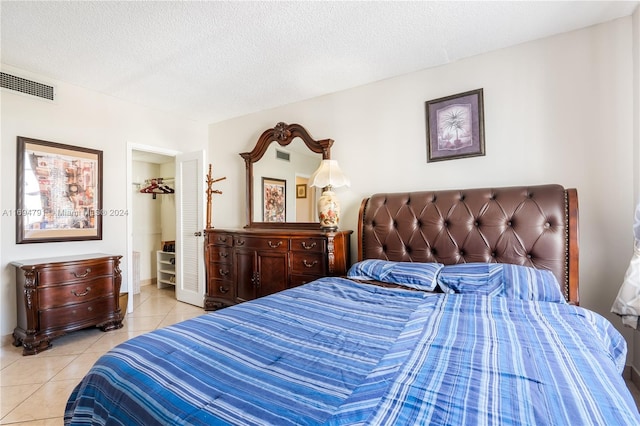 bedroom featuring light tile patterned floors and a textured ceiling