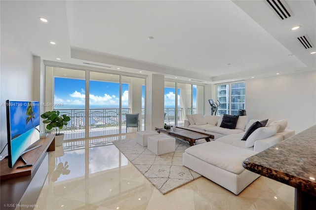 living room with a tray ceiling and expansive windows