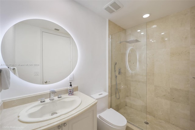 bathroom with a tile shower, vanity, and toilet