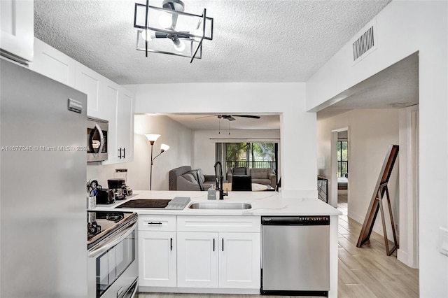 kitchen featuring sink, white cabinets, stainless steel appliances, and light hardwood / wood-style floors