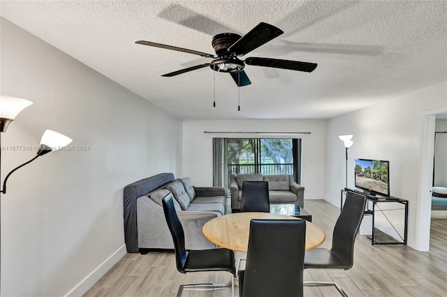 dining space with a textured ceiling and light wood-type flooring